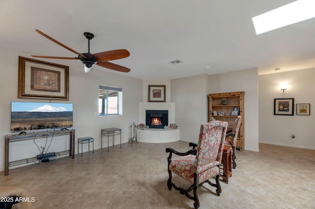 sitting room with a large fireplace and ceiling fan