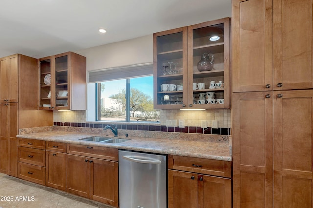 kitchen with sink, light tile patterned floors, backsplash, light stone countertops, and stainless steel dishwasher