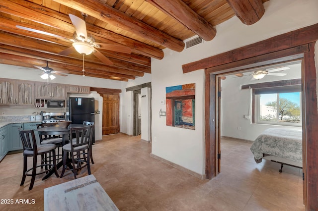 kitchen featuring a breakfast bar area, gray cabinetry, wooden ceiling, beamed ceiling, and black appliances