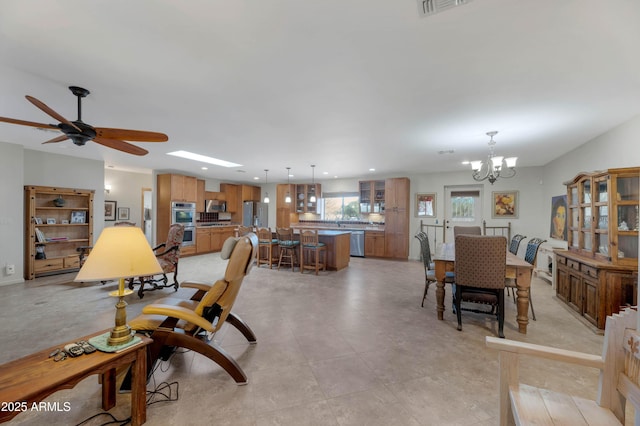 living room featuring ceiling fan with notable chandelier