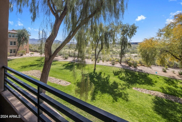 view of property's community with a mountain view and a lawn