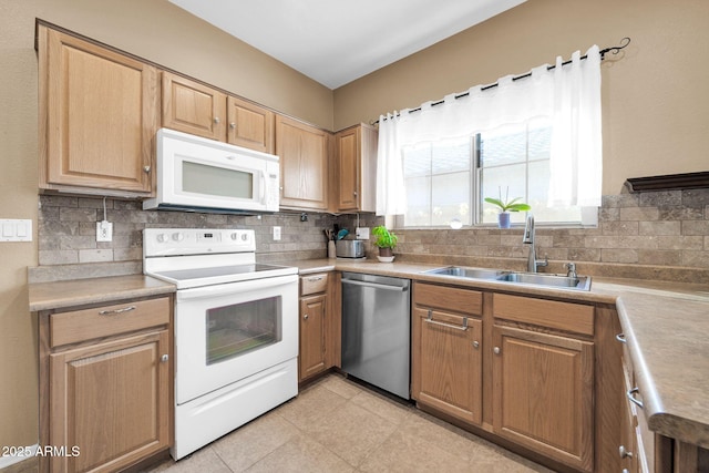 kitchen featuring backsplash, sink, and white appliances