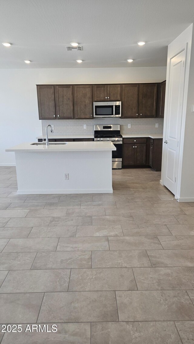 22319 W Monona Ln, Surprise, AZ 85387 - kitchen featuring stainless steel appliances, dark brown cabinetry, decorative backsplash, baseboards, and recessed lighting
