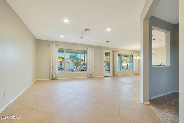 spare room featuring ceiling fan with notable chandelier and light tile patterned floors