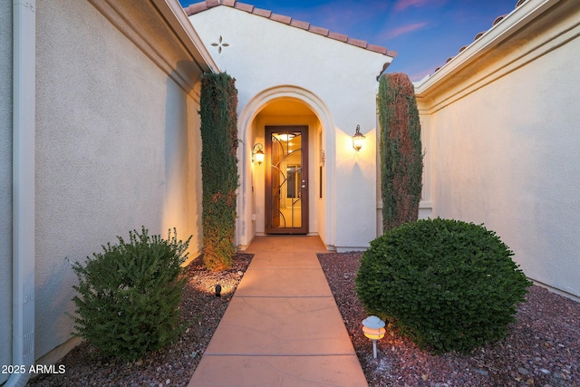 view of exterior entry at dusk