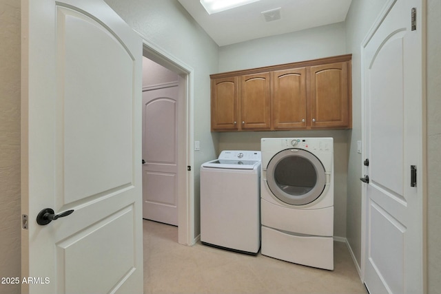 washroom featuring washer and clothes dryer and cabinets