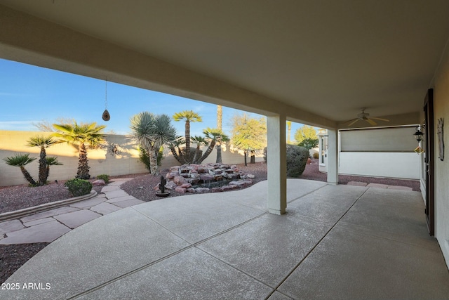 patio terrace at dusk featuring ceiling fan