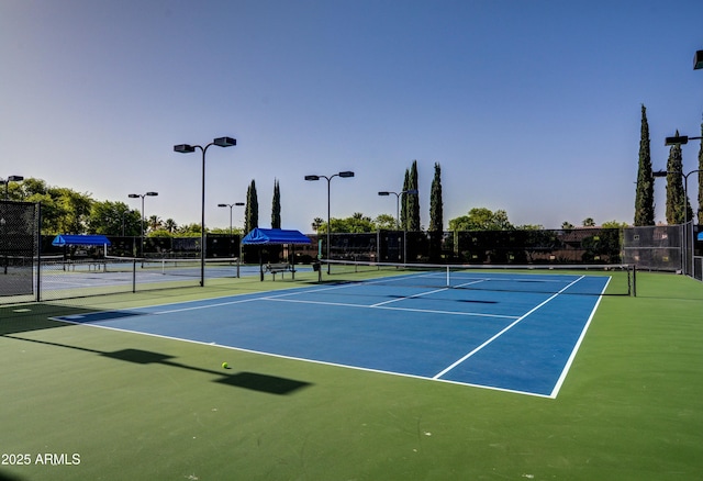 view of tennis court with basketball hoop