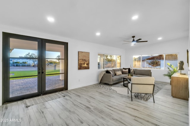 living room featuring french doors, ceiling fan, and light hardwood / wood-style flooring