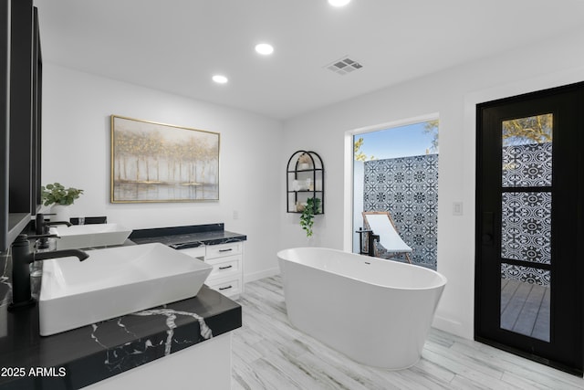 bathroom featuring a tub to relax in, sink, and hardwood / wood-style floors