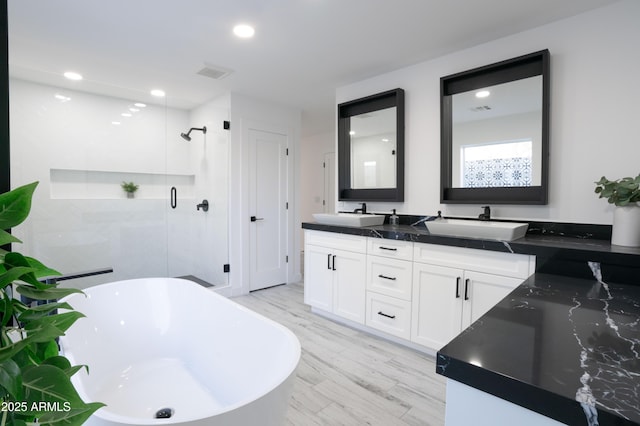 bathroom featuring vanity, wood-type flooring, and plus walk in shower