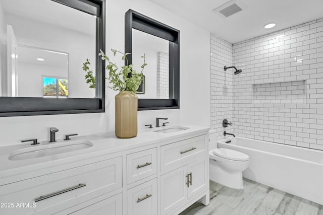 full bathroom featuring vanity, tiled shower / bath combo, and toilet