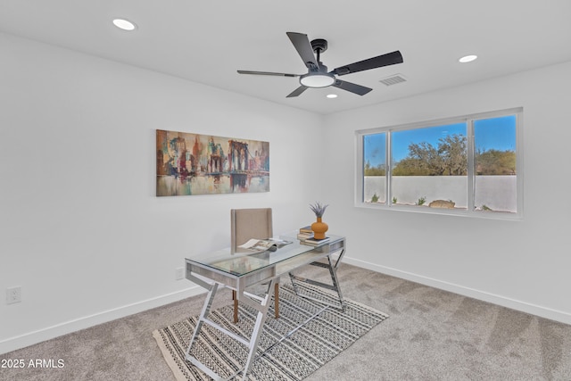 carpeted home office featuring ceiling fan