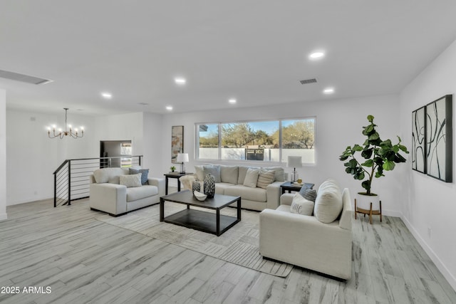 living room with an inviting chandelier and light hardwood / wood-style flooring