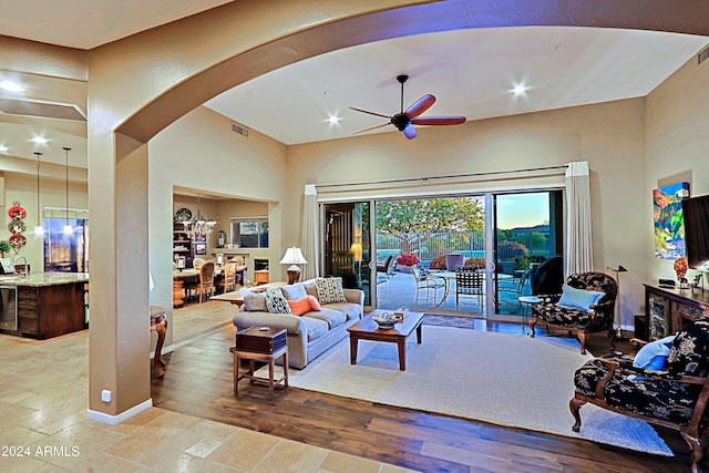 living room with hardwood / wood-style floors and ceiling fan with notable chandelier