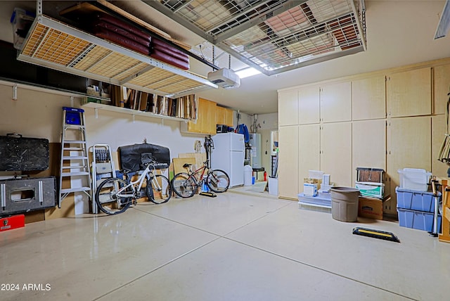 garage with a garage door opener, water heater, and white fridge