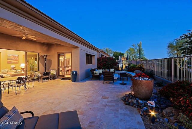 patio terrace at dusk featuring ceiling fan and an outdoor hangout area