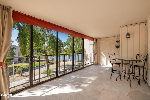 sunroom / solarium featuring a water view