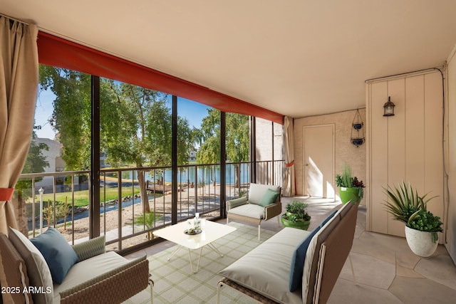 sunroom featuring a water view