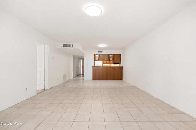 unfurnished living room with visible vents and light tile patterned floors