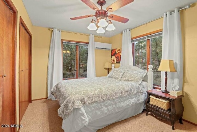 bedroom with light colored carpet, an AC wall unit, and ceiling fan