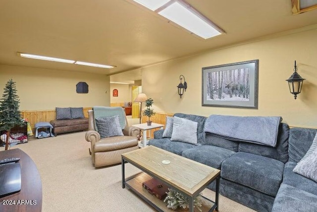 carpeted living room with wood walls