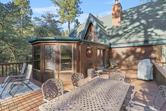 rear view of house with a sunroom and a wooden deck