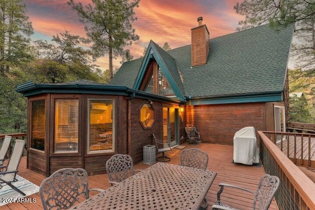 back house at dusk with a deck