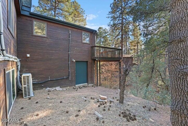 rear view of house with ac unit and a deck