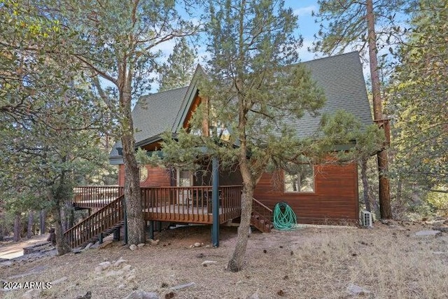 rear view of property featuring a wooden deck