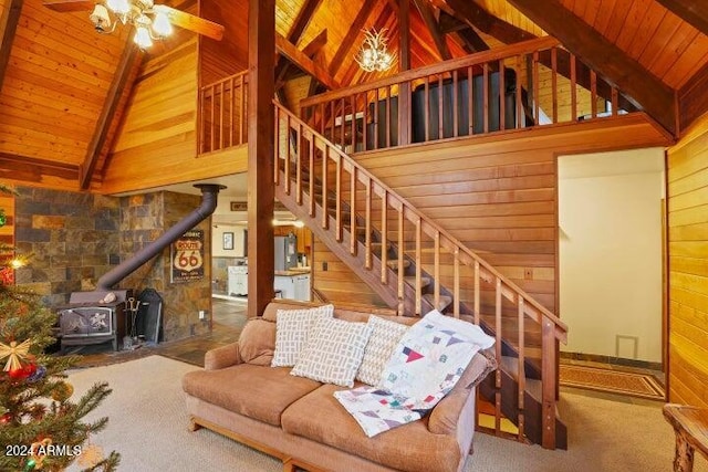 living room with wood walls, a wood stove, high vaulted ceiling, beam ceiling, and wood ceiling