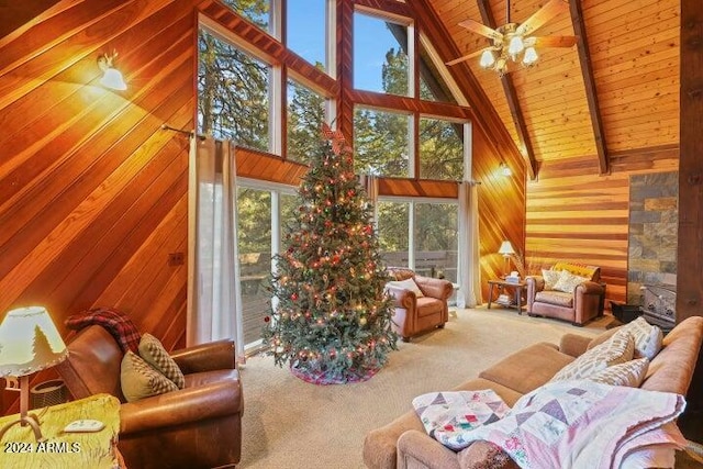 sunroom / solarium featuring lofted ceiling with beams, ceiling fan, plenty of natural light, and wood ceiling