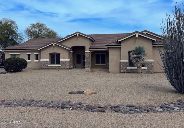 single story home with stucco siding, a tile roof, and stone siding