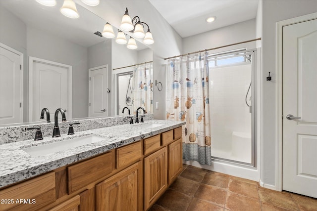 bathroom featuring a stall shower, double vanity, and a sink