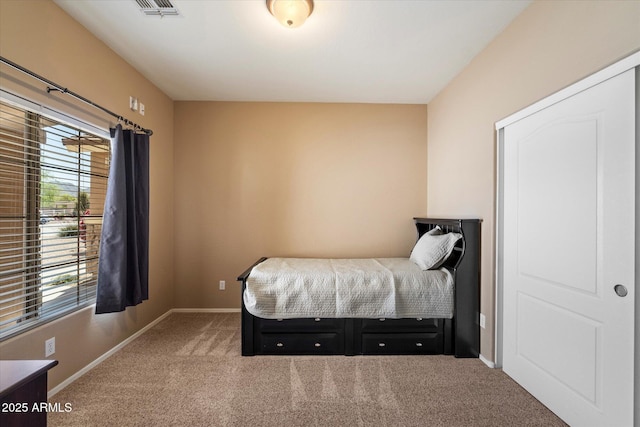 bedroom with baseboards, visible vents, carpet floors, and multiple windows
