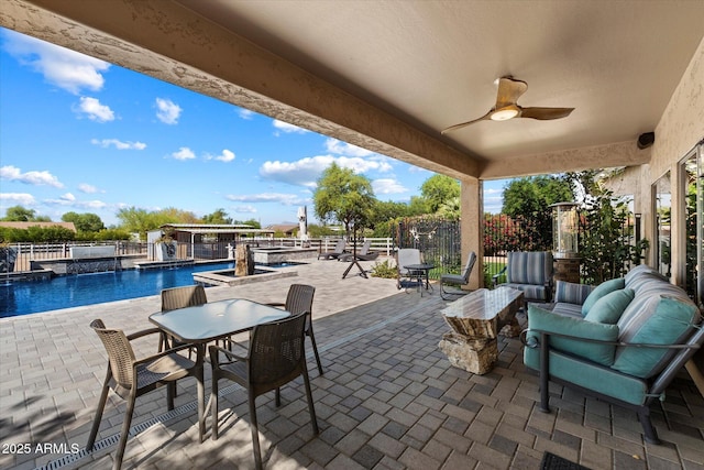 view of patio with outdoor dining area, ceiling fan, a pool with connected hot tub, and fence