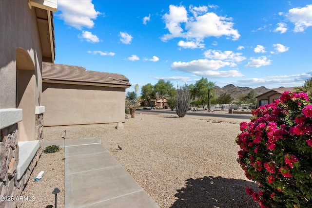 view of yard featuring a mountain view and fence