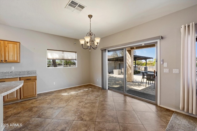 unfurnished dining area with visible vents, a notable chandelier, and baseboards