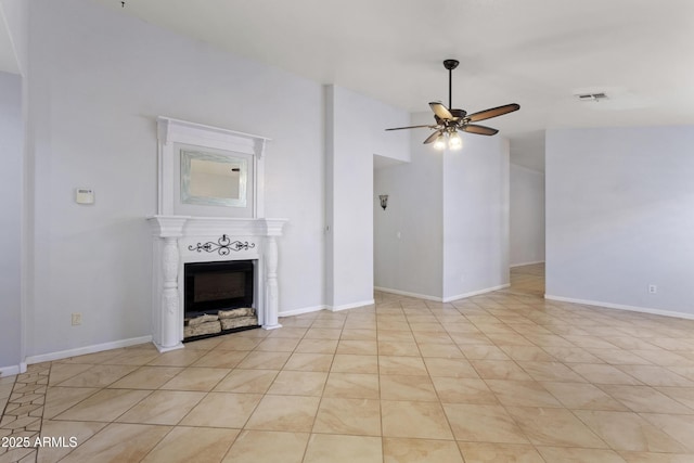 unfurnished living room with baseboards, ceiling fan, a fireplace, and visible vents