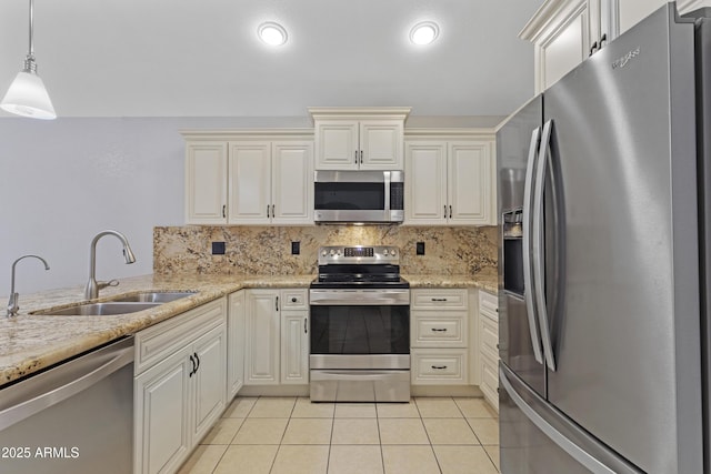 kitchen with stainless steel appliances, light tile patterned floors, decorative backsplash, and a sink