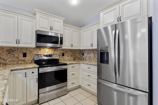 kitchen featuring tasteful backsplash, light tile patterned floors, light stone counters, lofted ceiling, and stainless steel appliances