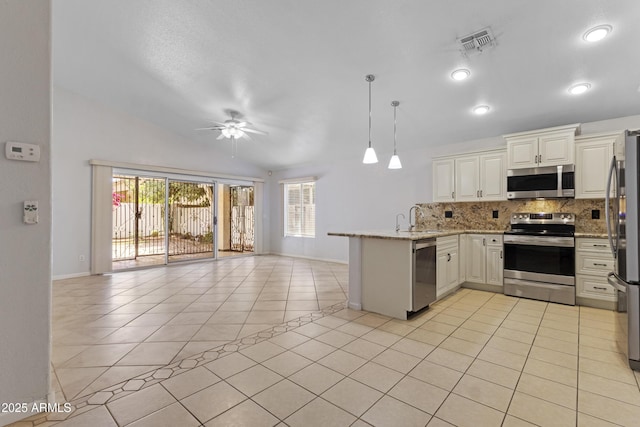 kitchen with visible vents, appliances with stainless steel finishes, a peninsula, open floor plan, and a wealth of natural light