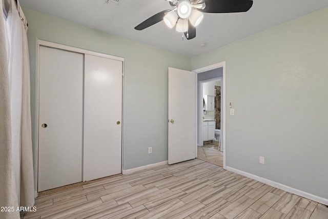 unfurnished bedroom featuring a closet, baseboards, a ceiling fan, and wood tiled floor