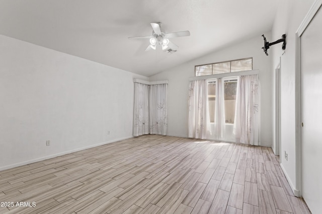 empty room featuring baseboards, light wood-style flooring, ceiling fan, and vaulted ceiling