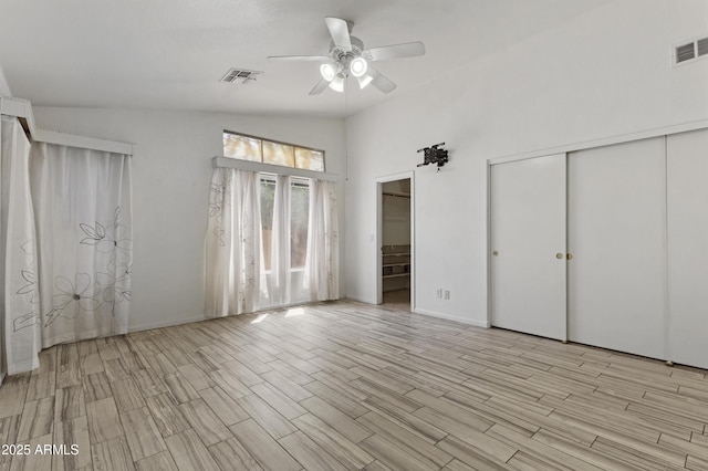 unfurnished bedroom featuring multiple closets, visible vents, and light wood finished floors