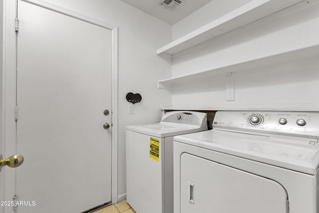 laundry room featuring light tile patterned floors, laundry area, independent washer and dryer, and visible vents