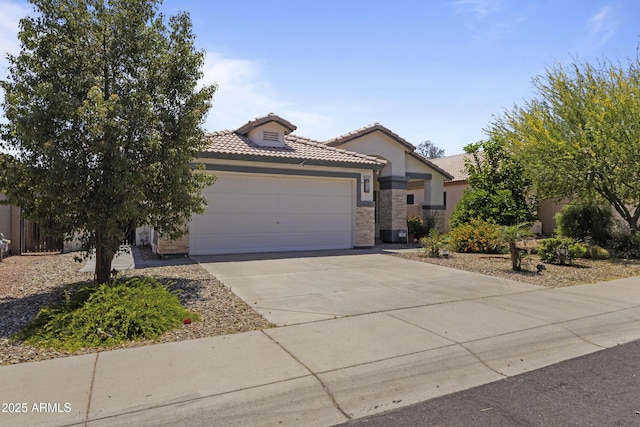 view of front of property with a tiled roof, driveway, a garage, stone siding, and stucco siding