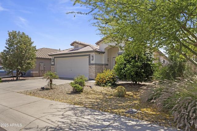view of property hidden behind natural elements featuring stone siding, a garage, stucco siding, concrete driveway, and a tiled roof
