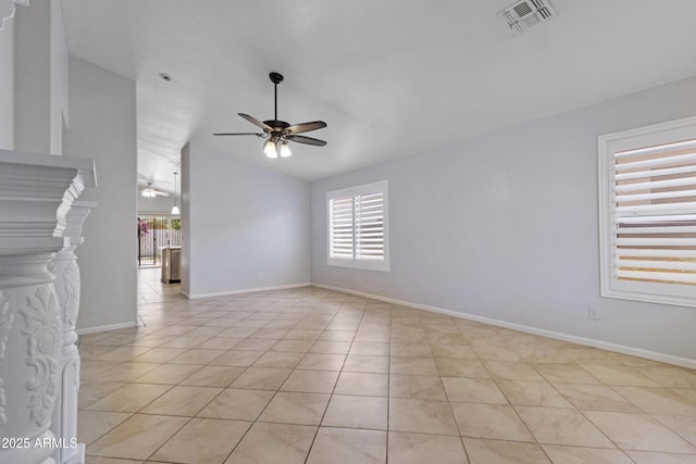 spare room featuring ceiling fan, visible vents, vaulted ceiling, light tile patterned floors, and baseboards
