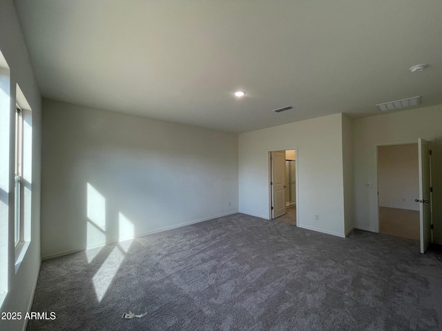 unfurnished room with dark carpet